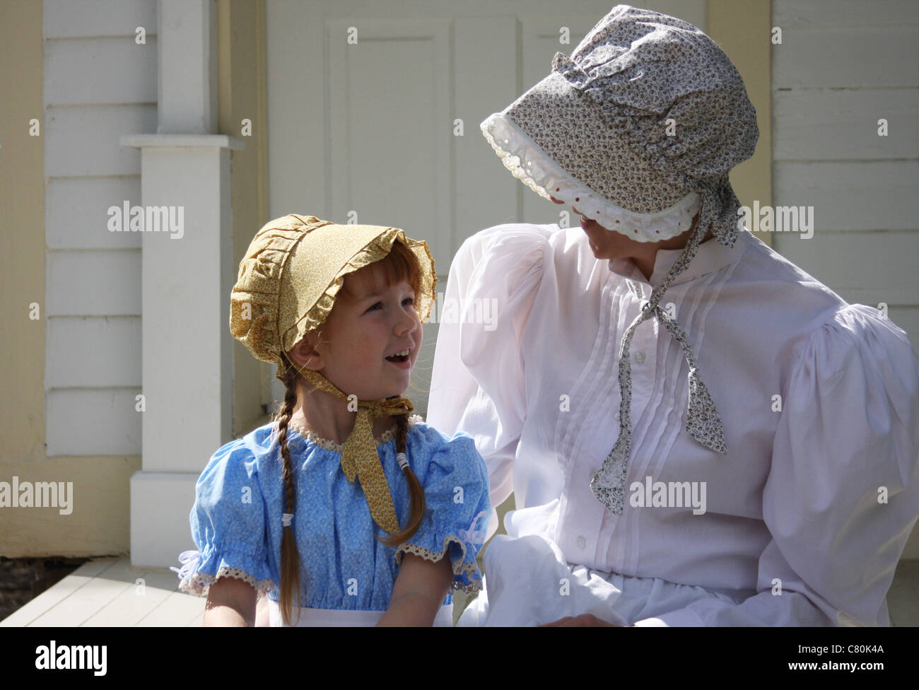 A woman and girl sitting on a porch Stock Photo - Alamy