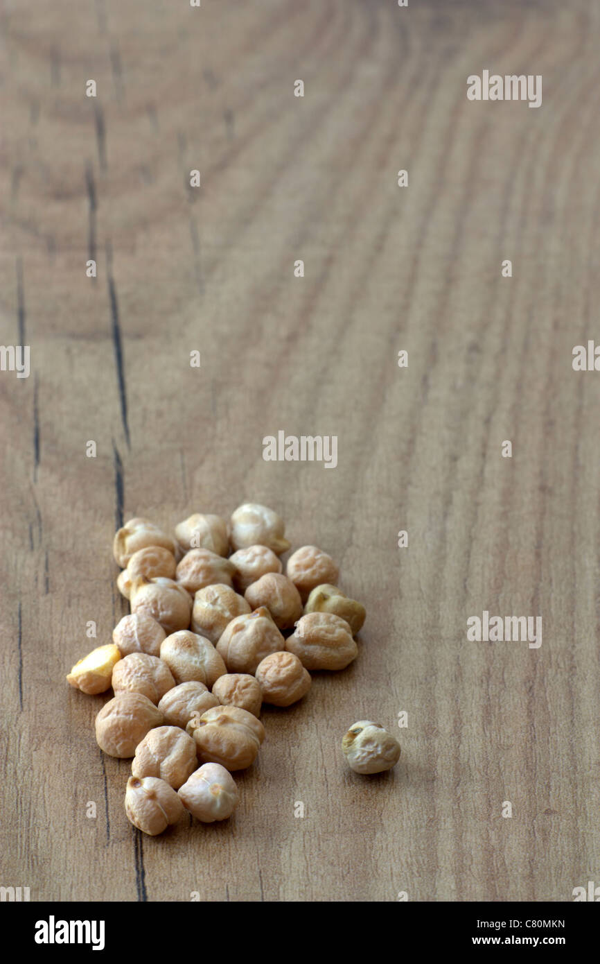 Selective focus image of dried chickpeas placed on a wooden board with copy space. Stock Photo