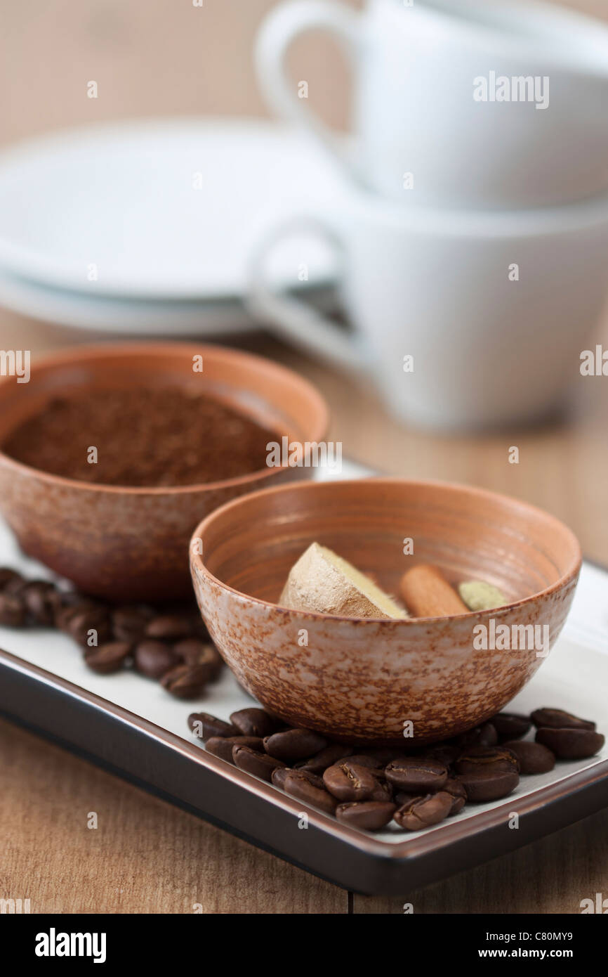 Bowls with powdered coffee and ginger, cinnamon and cardamom, the ingredients for Indian coffee. Stock Photo