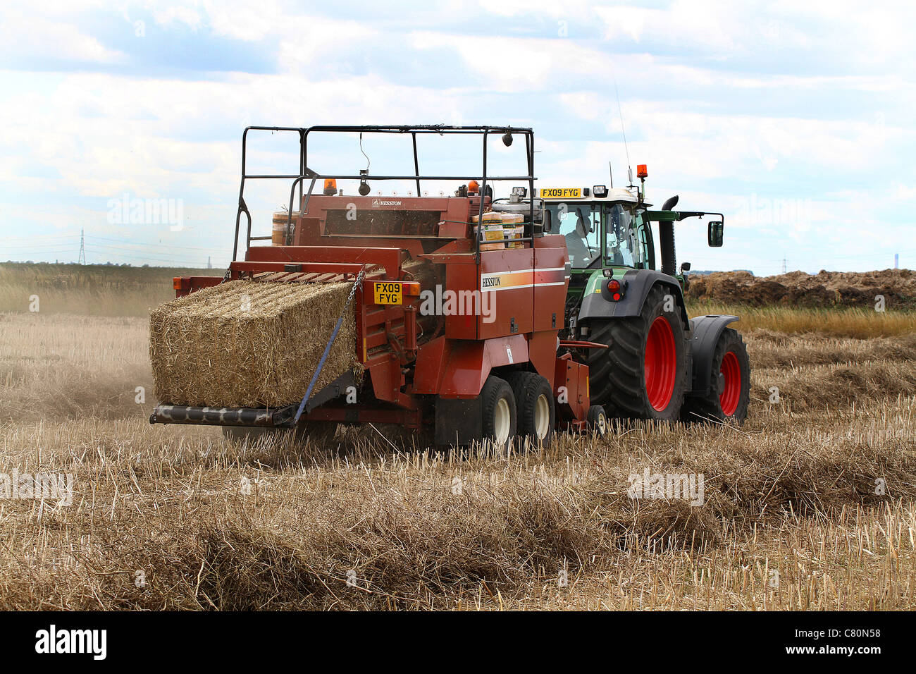 Tractor and straw baler unit in action Stock Photo - Alamy