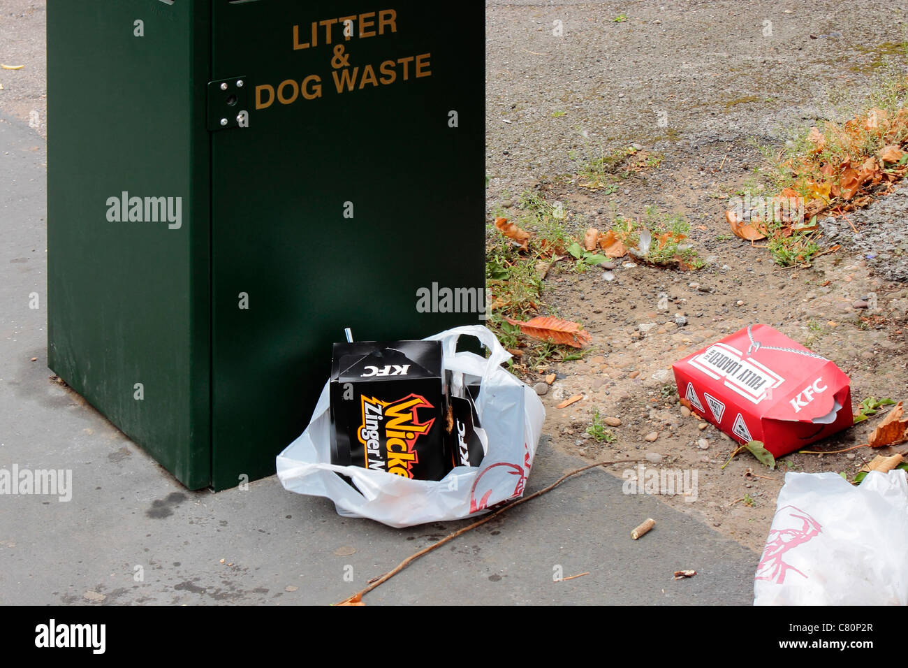KFC Packaging carelessly discarded next to a litter bin Stock Photo