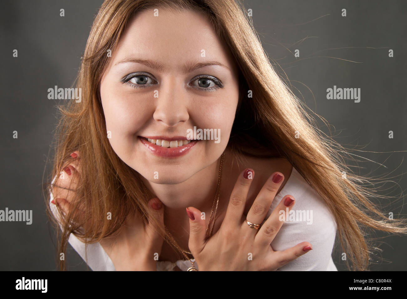 Beautiful woman smiles on a grey background Stock Photo