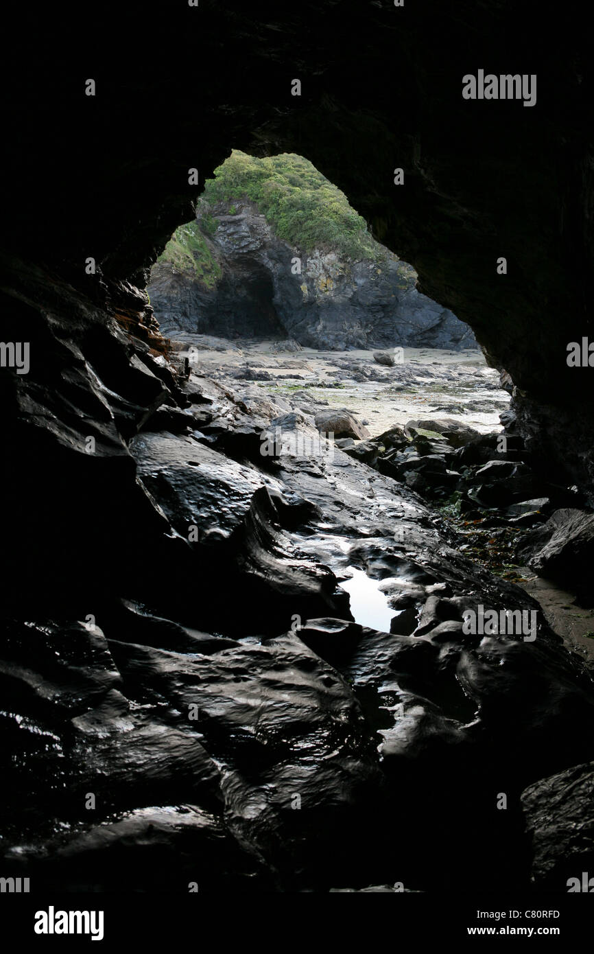 View from inside a cave looking towards the opening and on to another cave in the background. Stock Photo