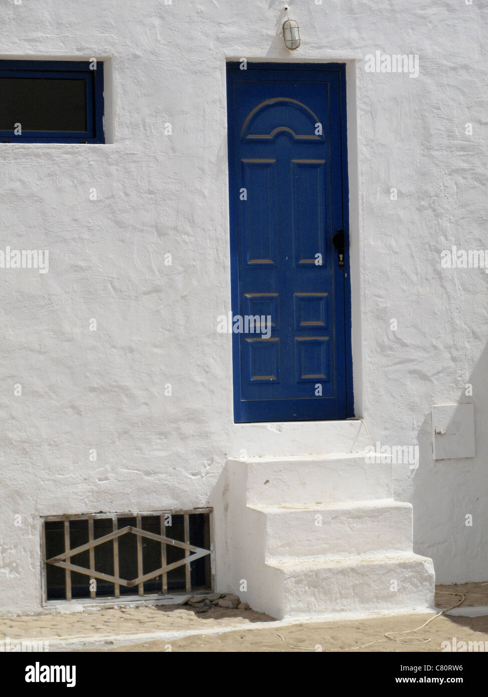 White washed stone building with blue door Stock Photo