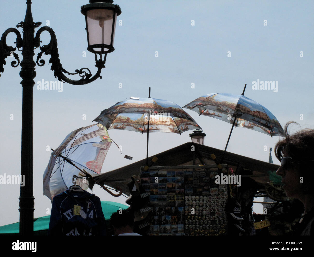 Old fashioned lamp post with a market stall selling umbrellas Venice Stock Photo