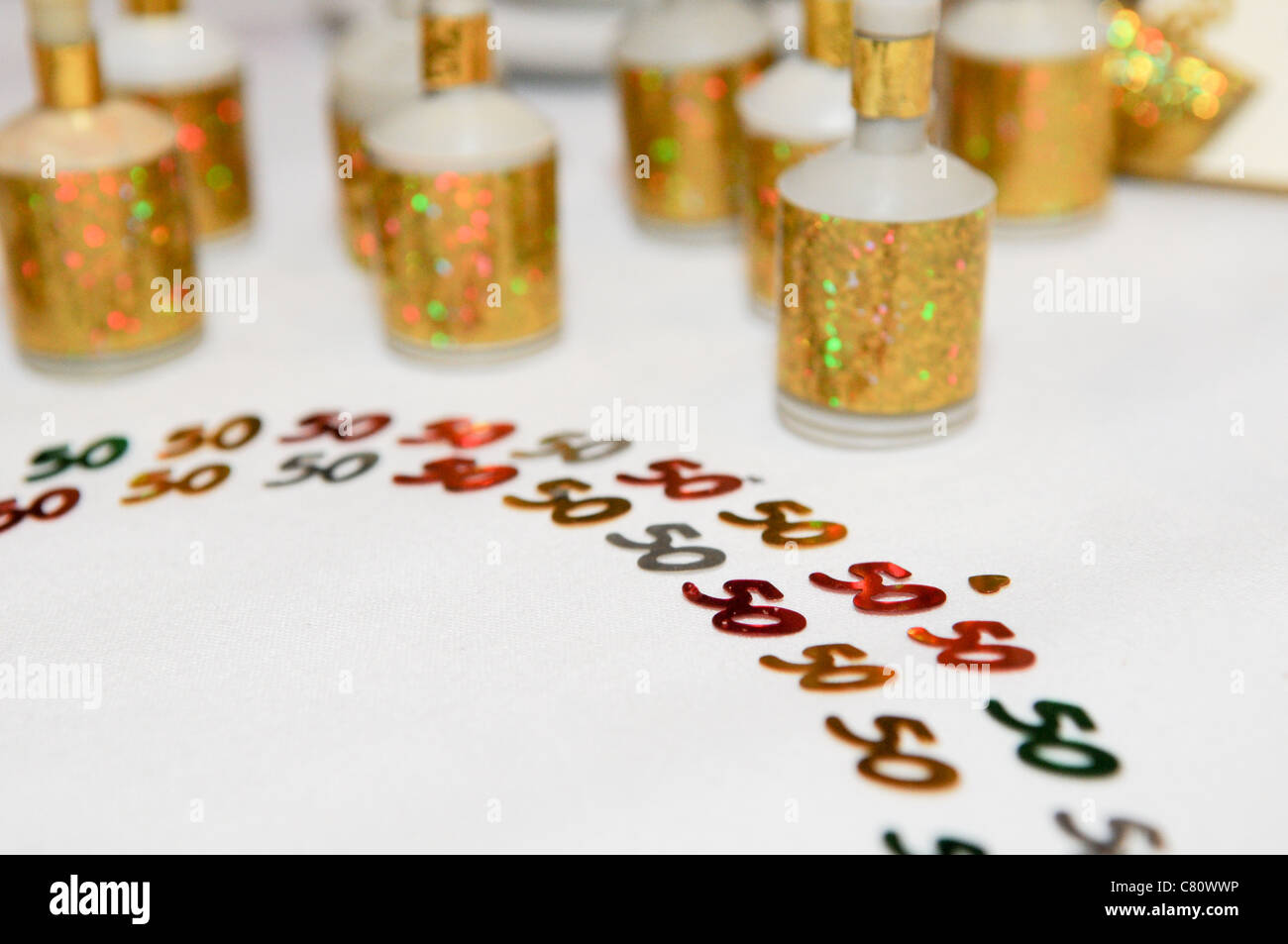 The number 50 made from glittering gold and red party popper numbers on a white table at a golden wedding celebration or fiftieth birthday party Stock Photo