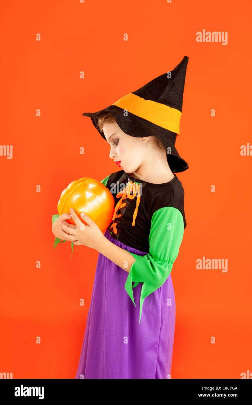 Halloween kid girl costume on orange background Stock Photo