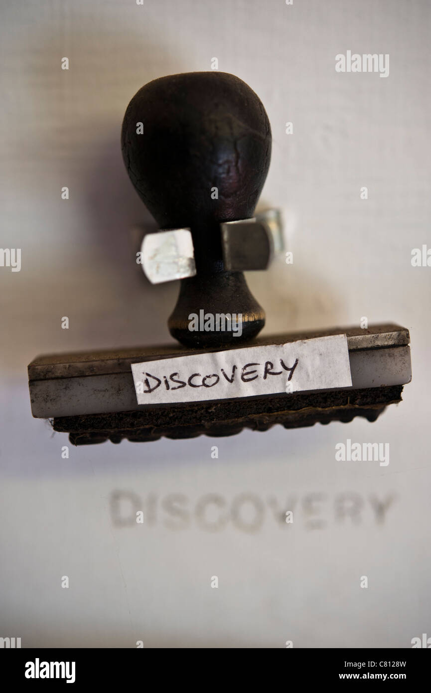 Rubber stamp with word discovery held in a clip on a wall Stock Photo