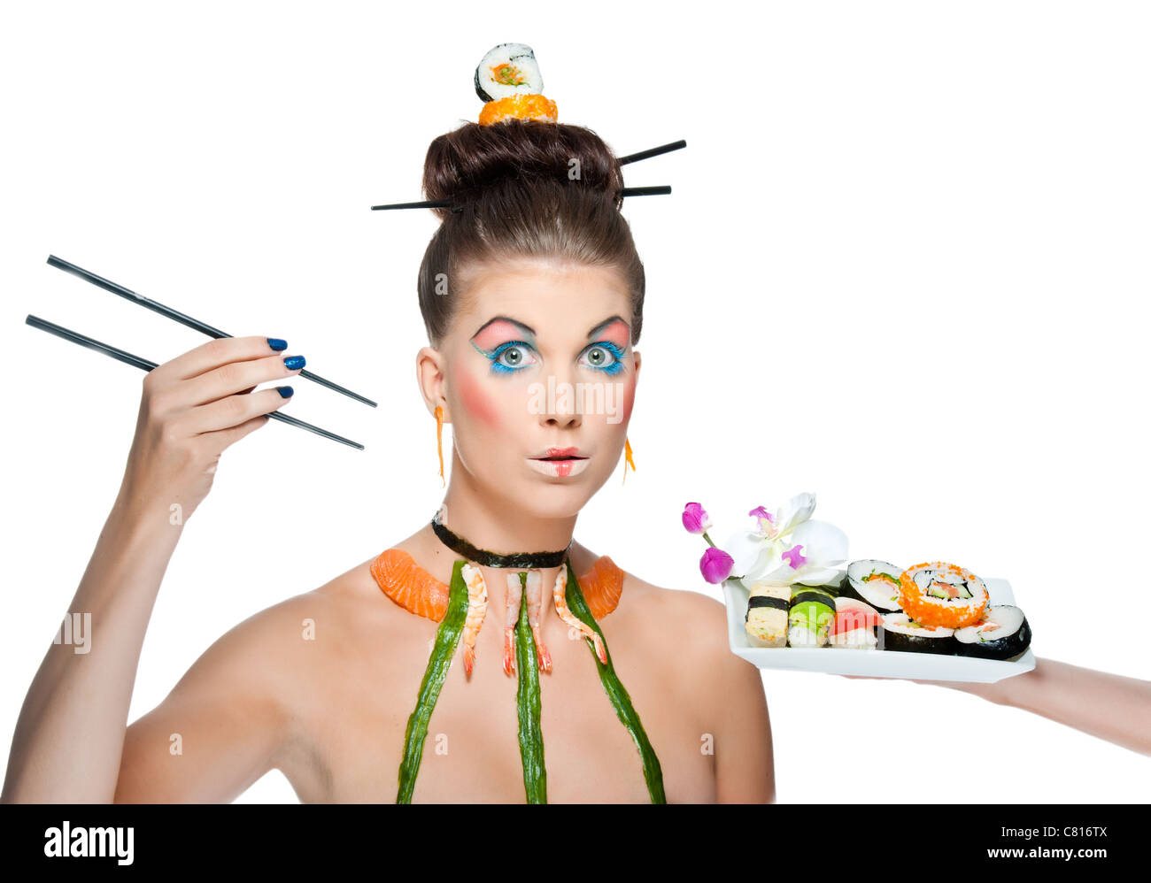 A creative and colorful image of a fashion model wearing asian themed makeup and raw sushi Stock Photo