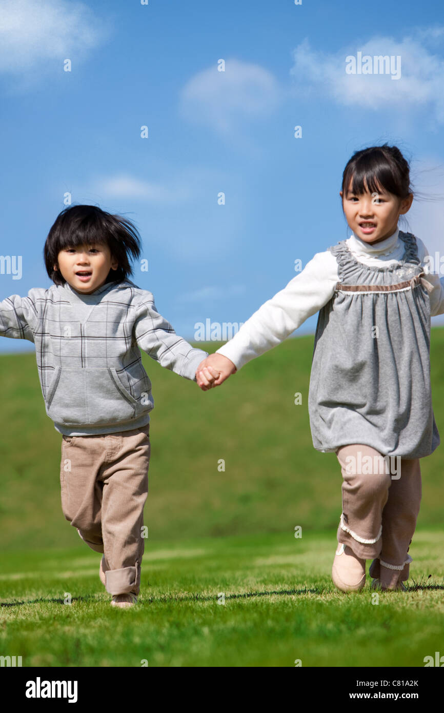 Sister and Brother Running in Hand in Hand Stock Photo - Alamy