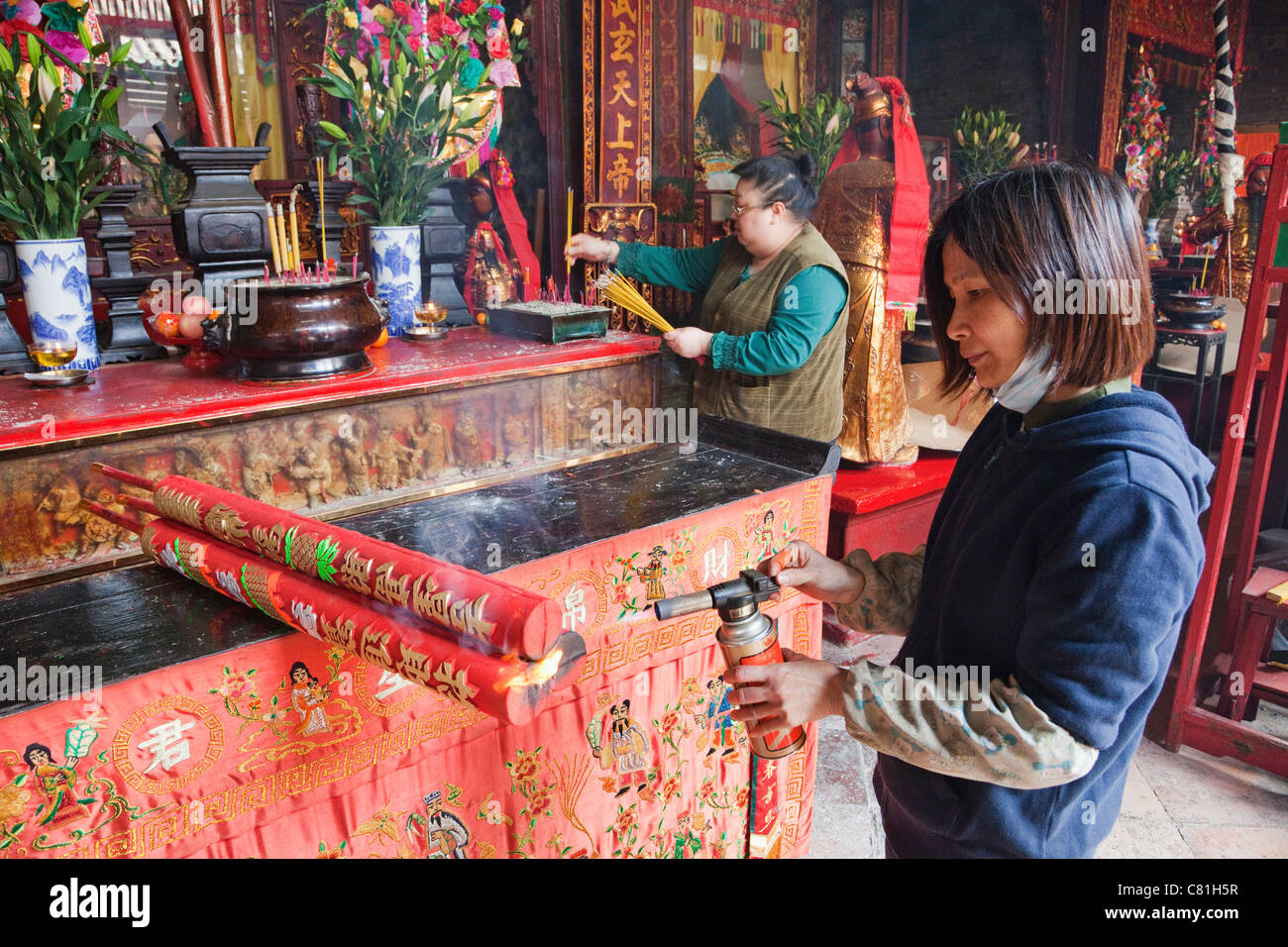 China, Macau, Sam Kai Vui Kun Temple, Temple Worker using Blow Torch to