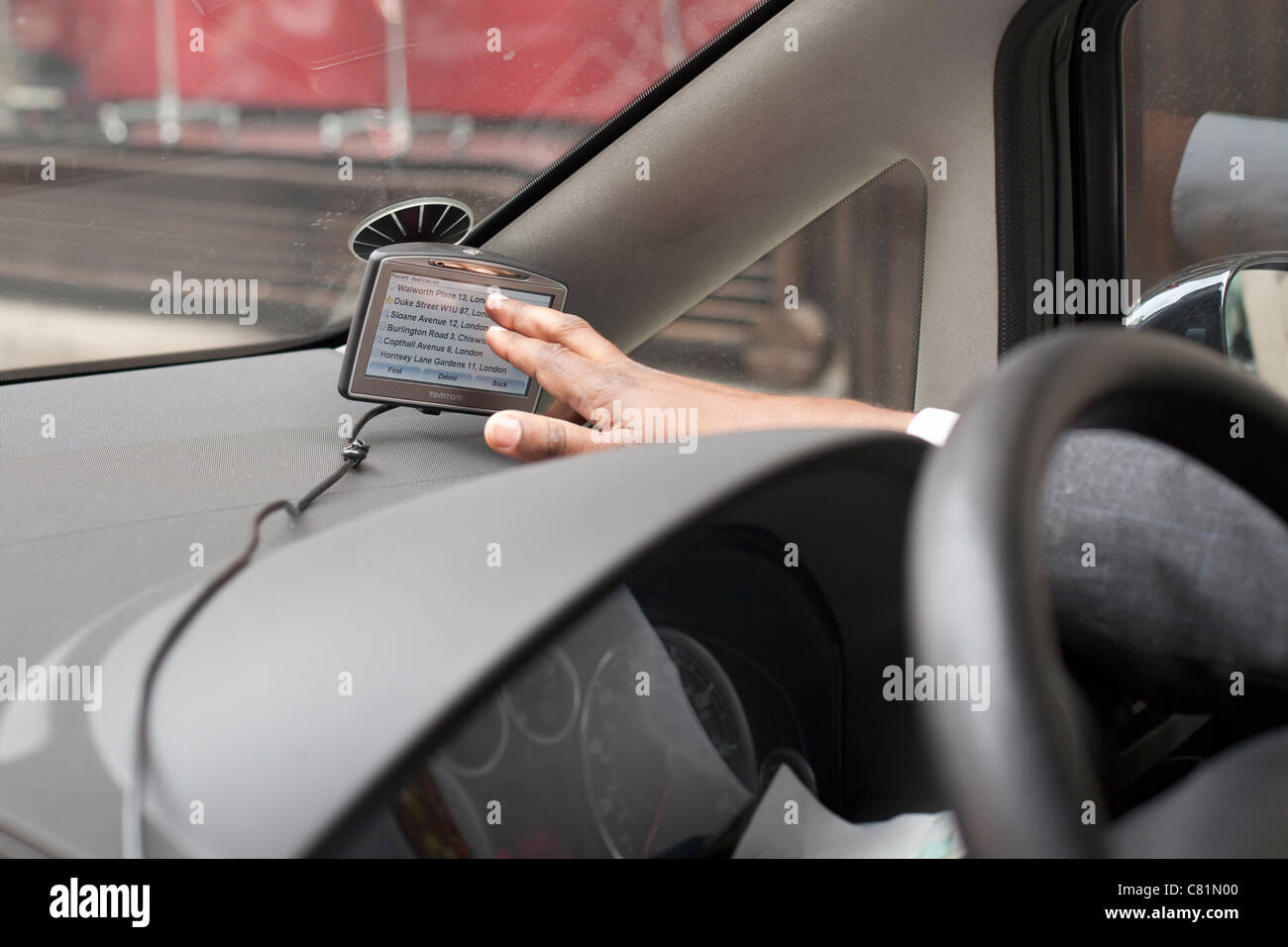 Male driver setting up a tomtom satnav in his car Stock Photo