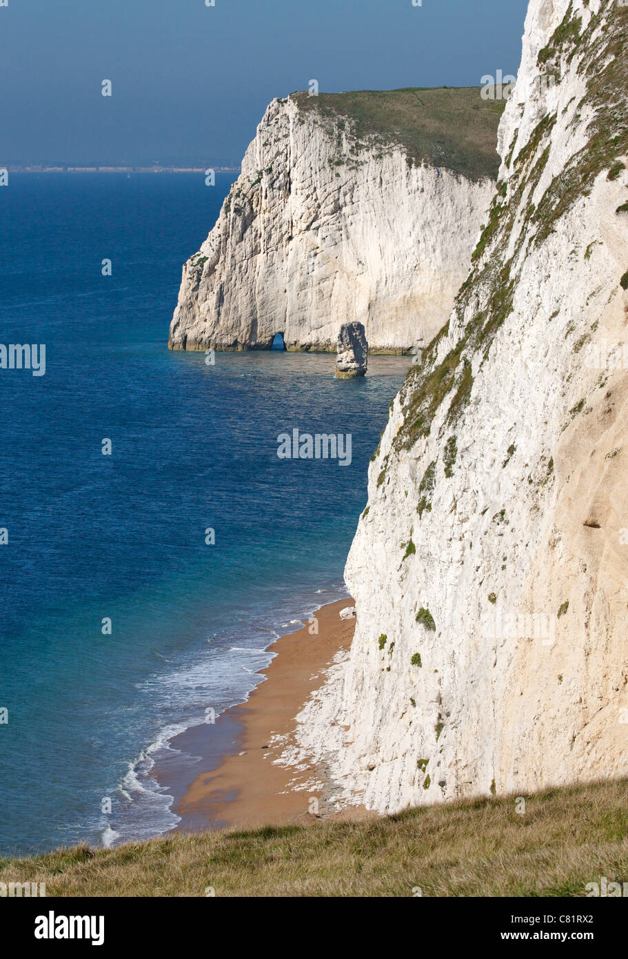 Chalk coastal cliffs in Dorset near Durdle Door looking towards Bat's Head and the small natural arch of Bat's Hole Stock Photo