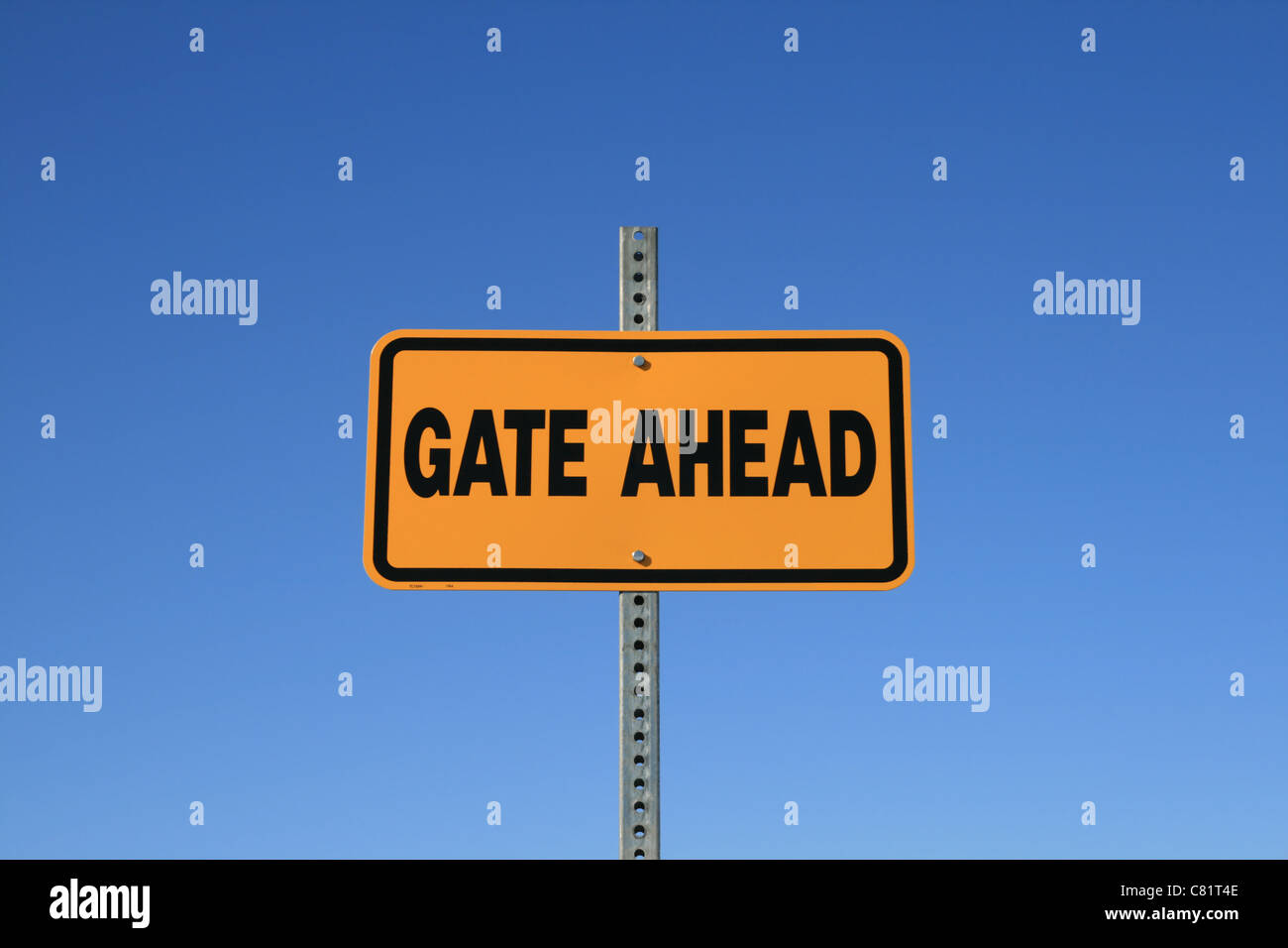 gate ahead road sign in yellow and black on blue sky background Stock