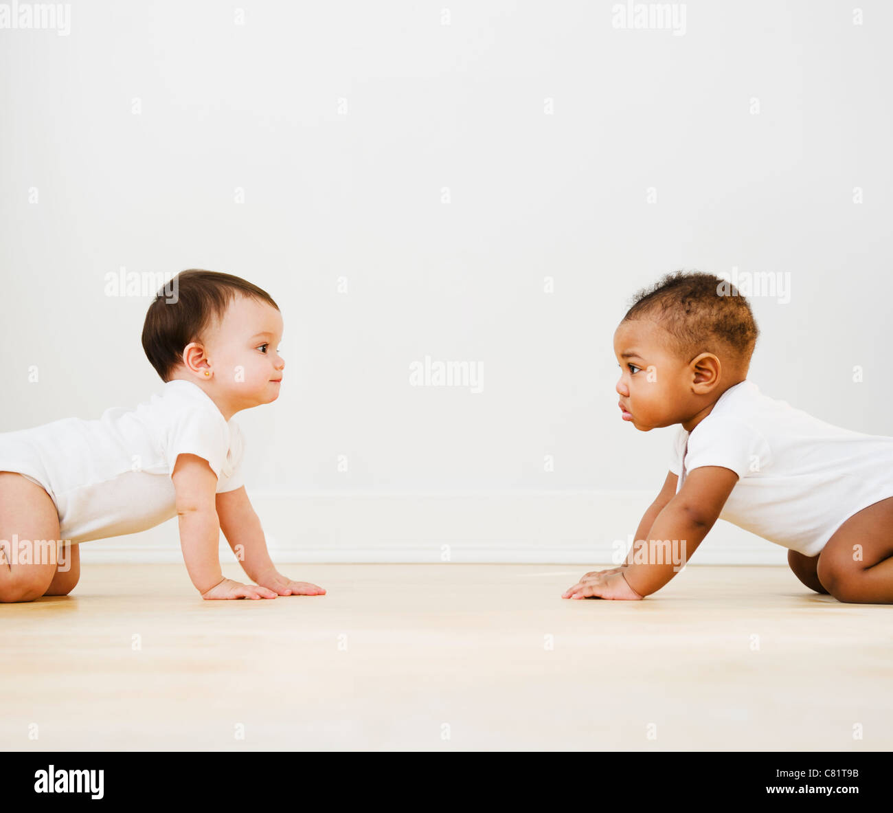 Babies crawling on floor Stock Photo