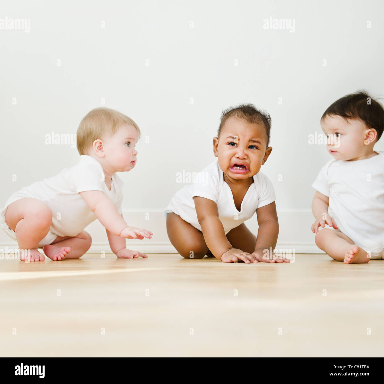 Babies watching crying friend Stock Photo