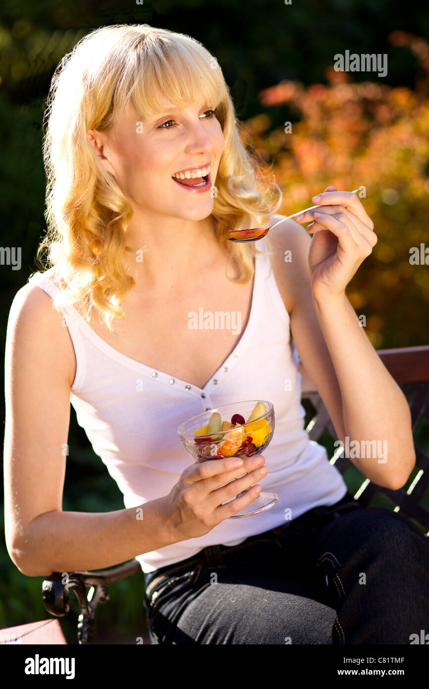 Woman eating fruit outdoors Stock Photo