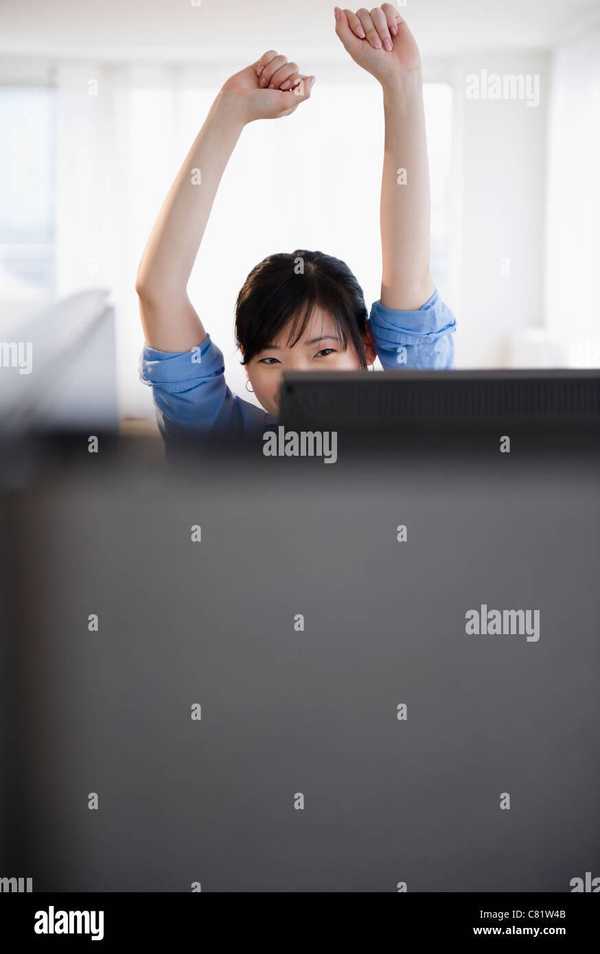 Korean woman stretching at desk Stock Photo