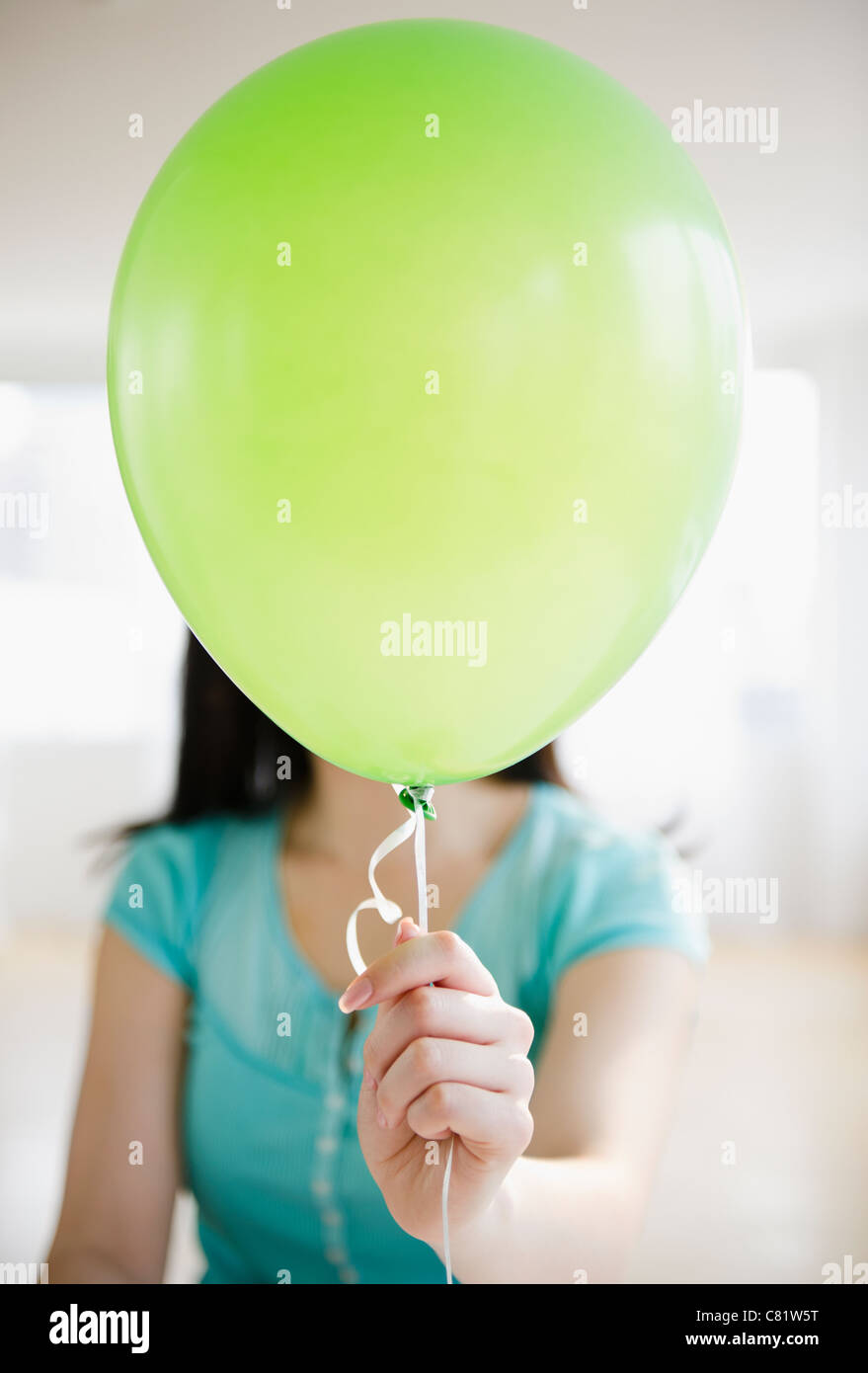 Korean woman holding balloon in front of her face Stock Photo