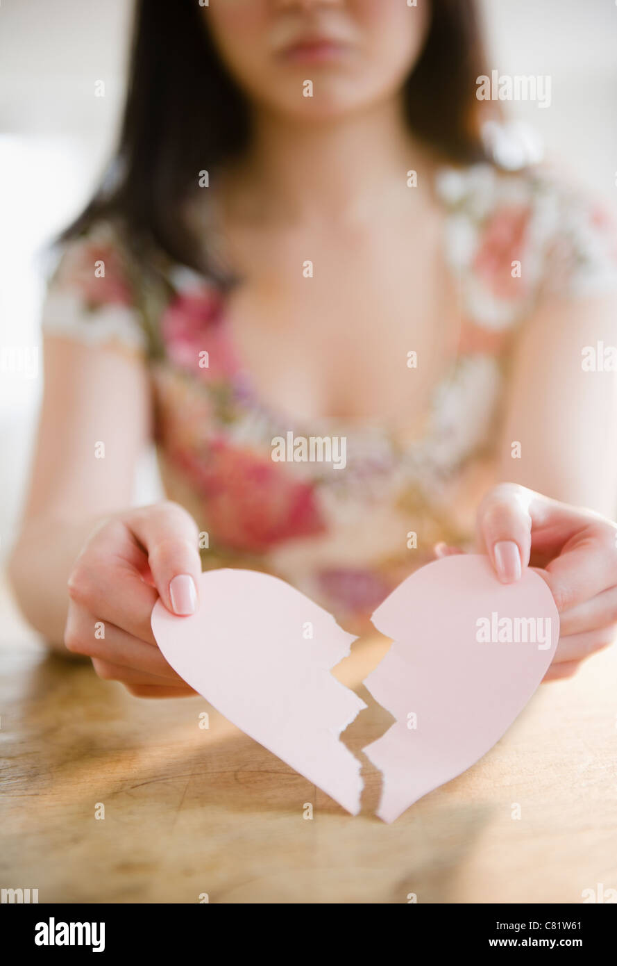 Korean woman holding torn paper heart Stock Photo - Alamy