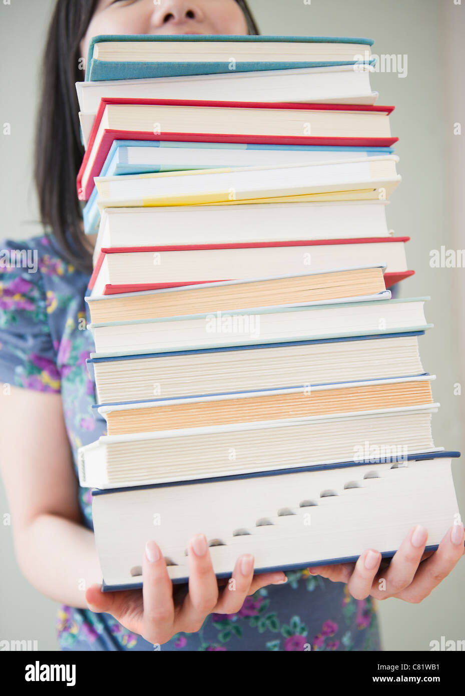 Korean woman holding stack of books Stock Photo