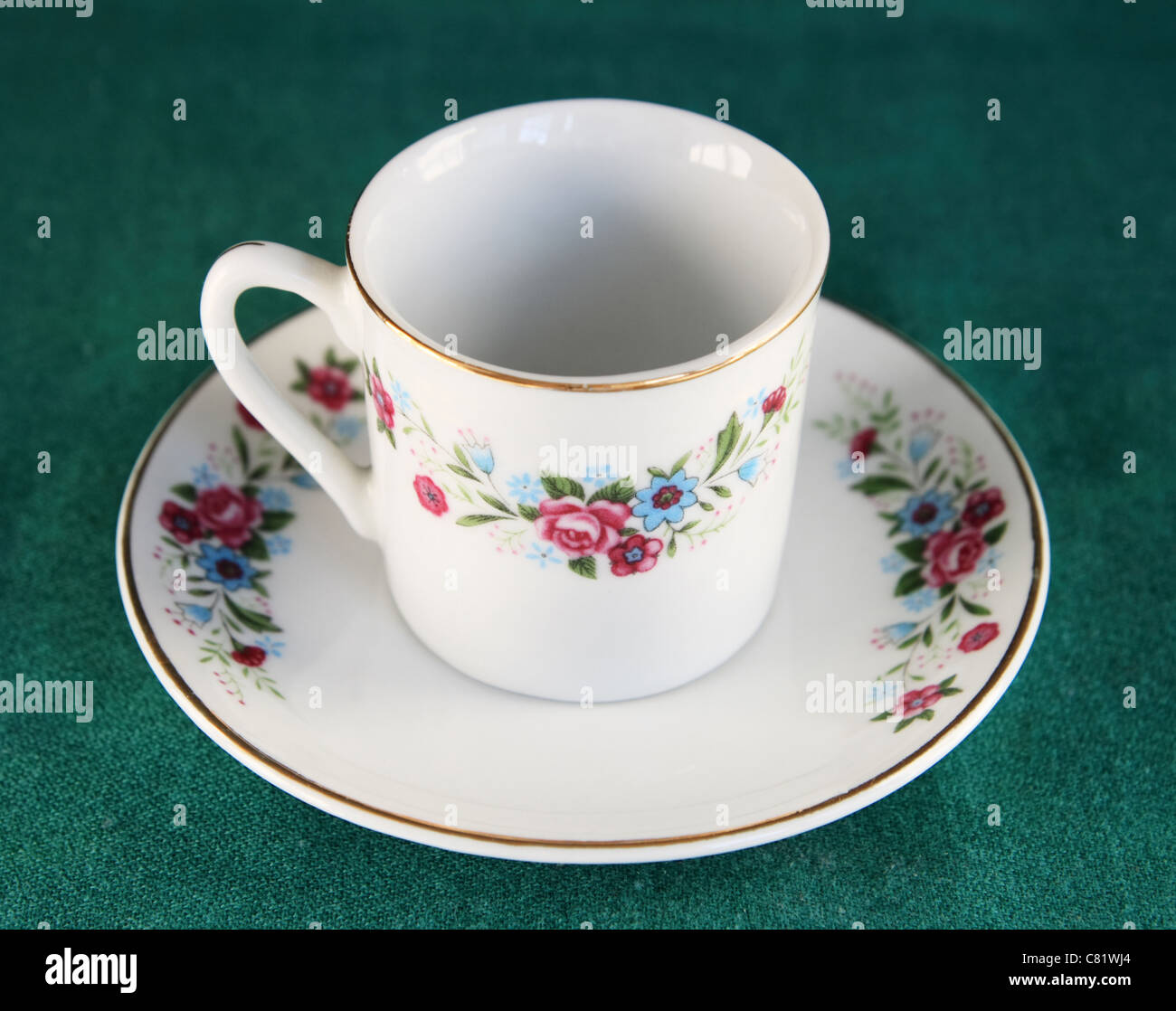 antique teacup and saucer on a green background Stock Photo