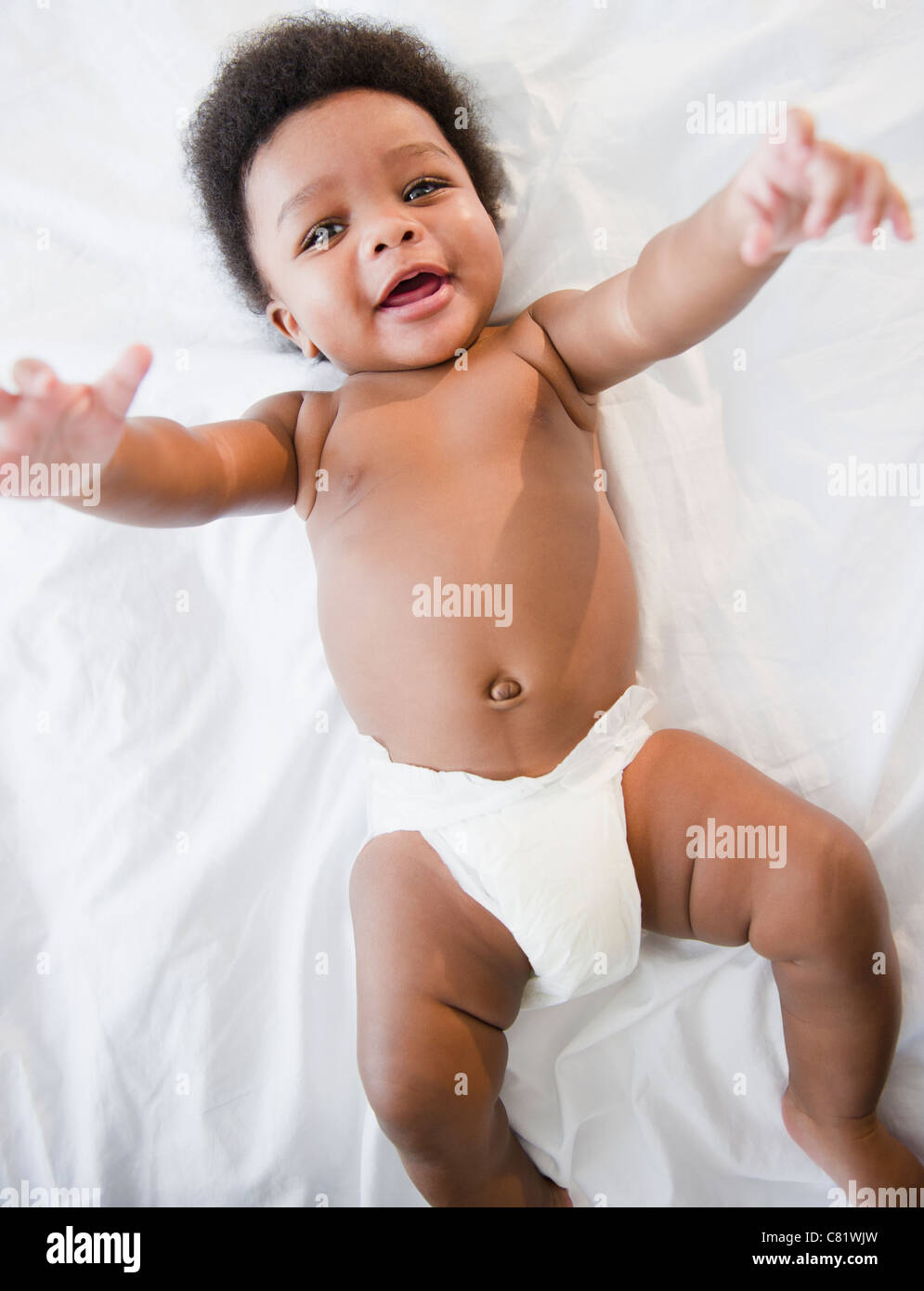 African American baby boy laying on bed Stock Photo