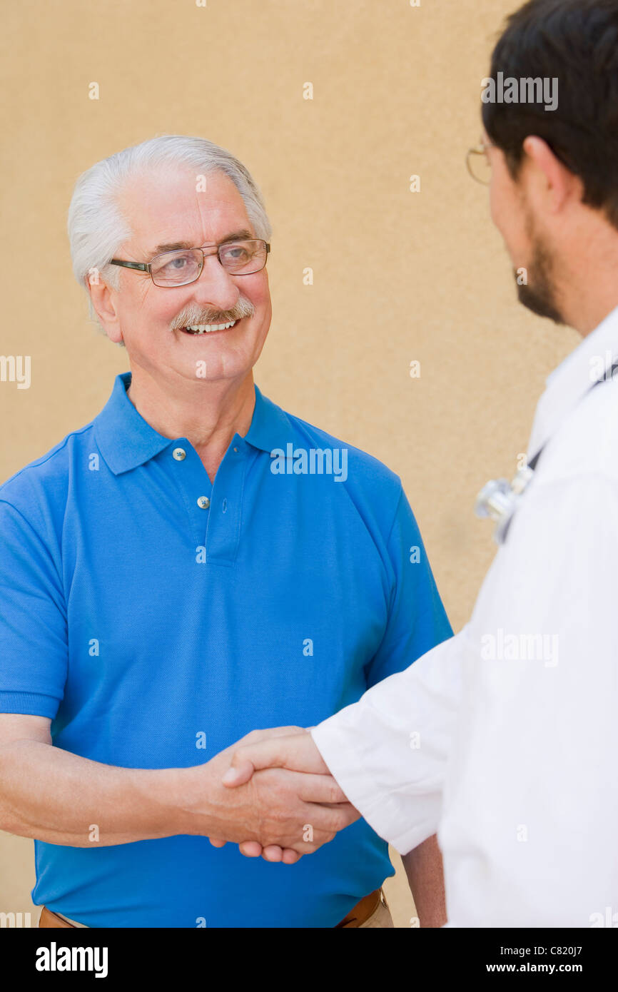 Senior man shaking hands with doctor Stock Photo Alamy