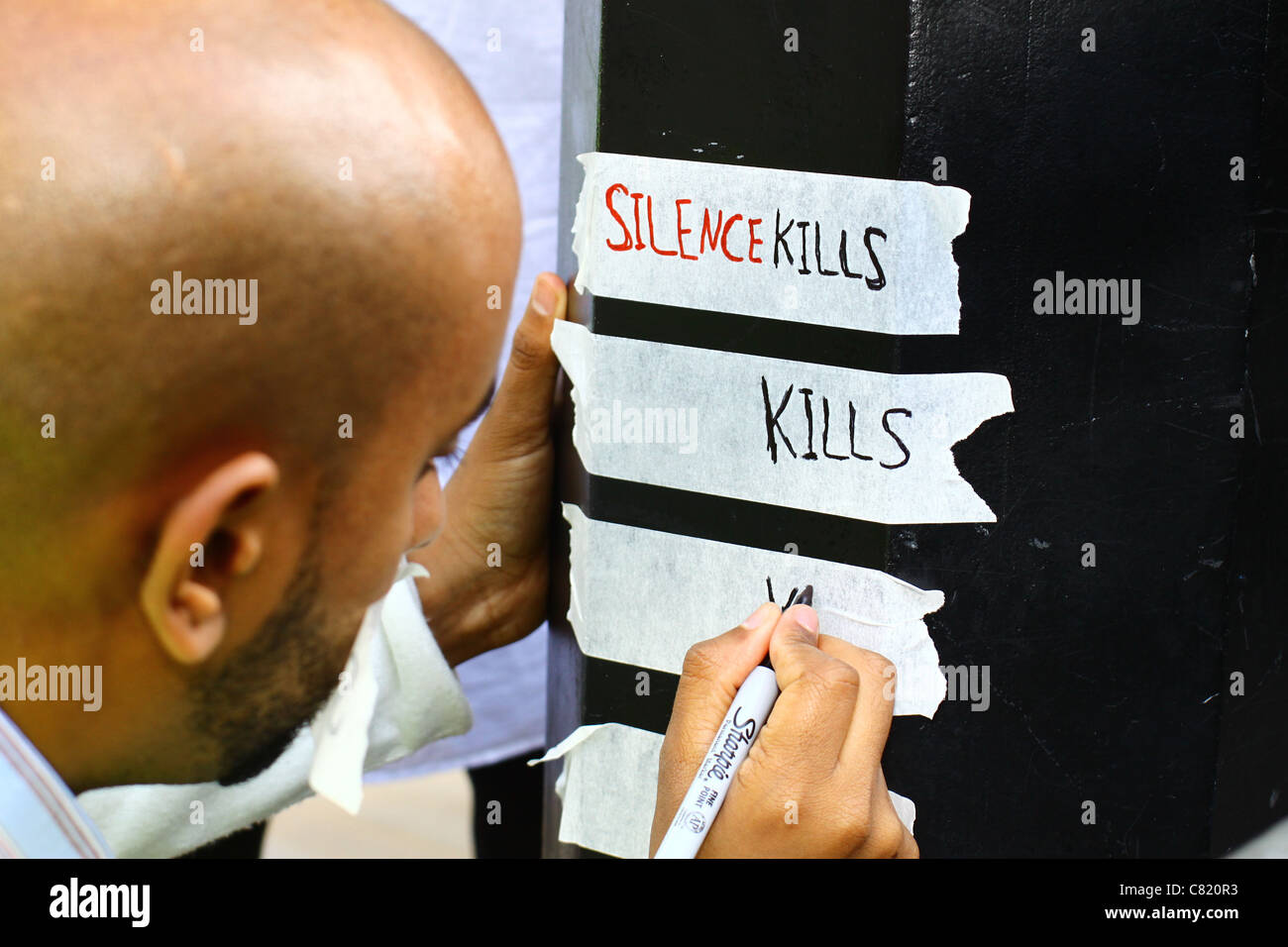 A man writes out a slogan at a silent protest in London to highlight the political situation in Yemen. Stock Photo