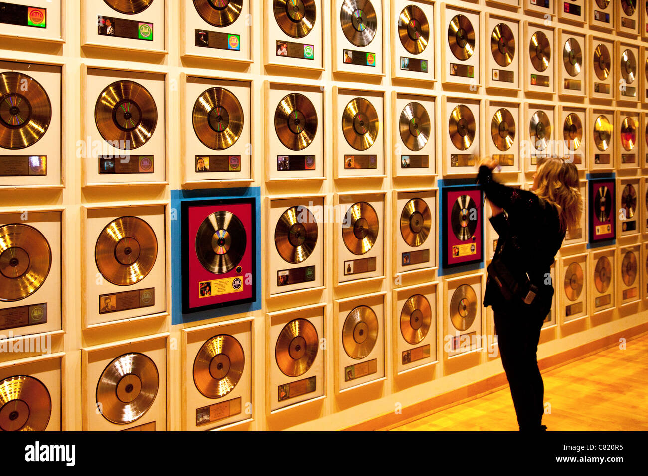 Music fan views collection of Gold and Platinum Albums at the Country Music Hall of Fame, Nashville Tennessee USA Stock Photo
