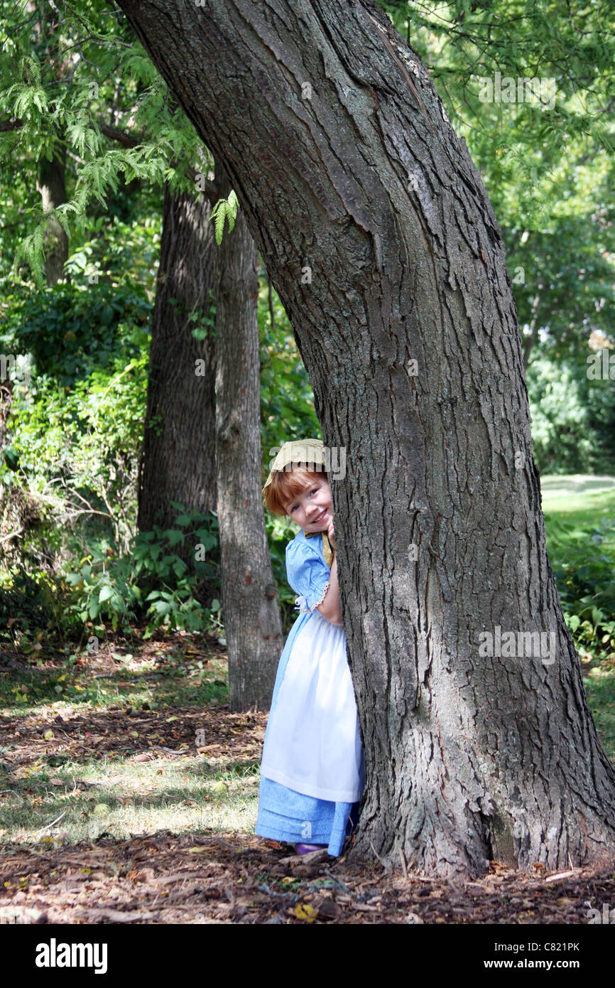 A young girl behind a tree Stock Photo