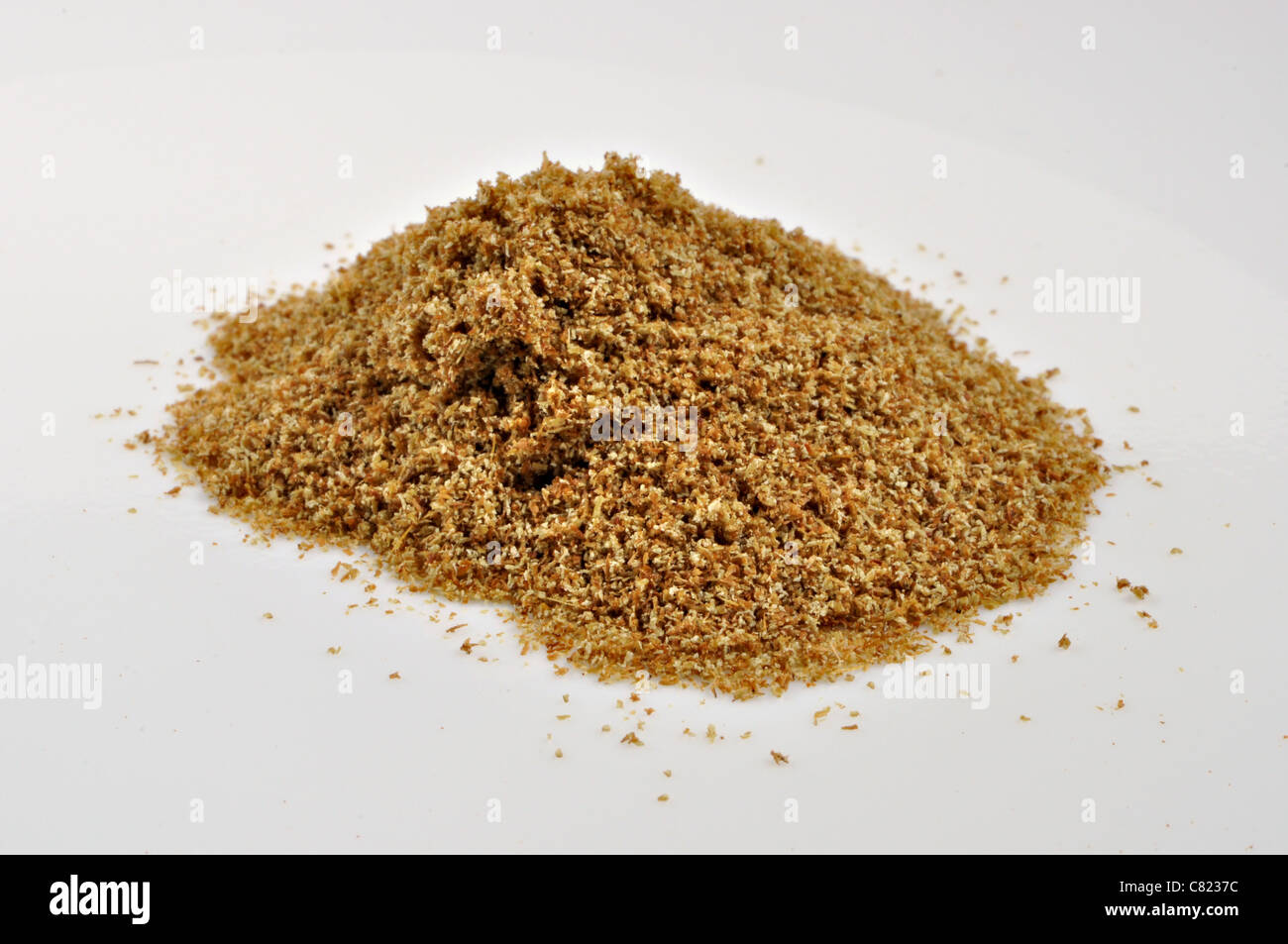A small pile of ground cumin sits on a plain white background. Stock Photo