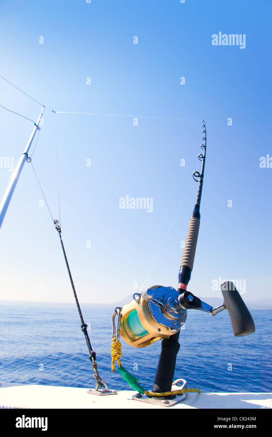 fishing boat trolling with outrigger gear and golden reel rod
