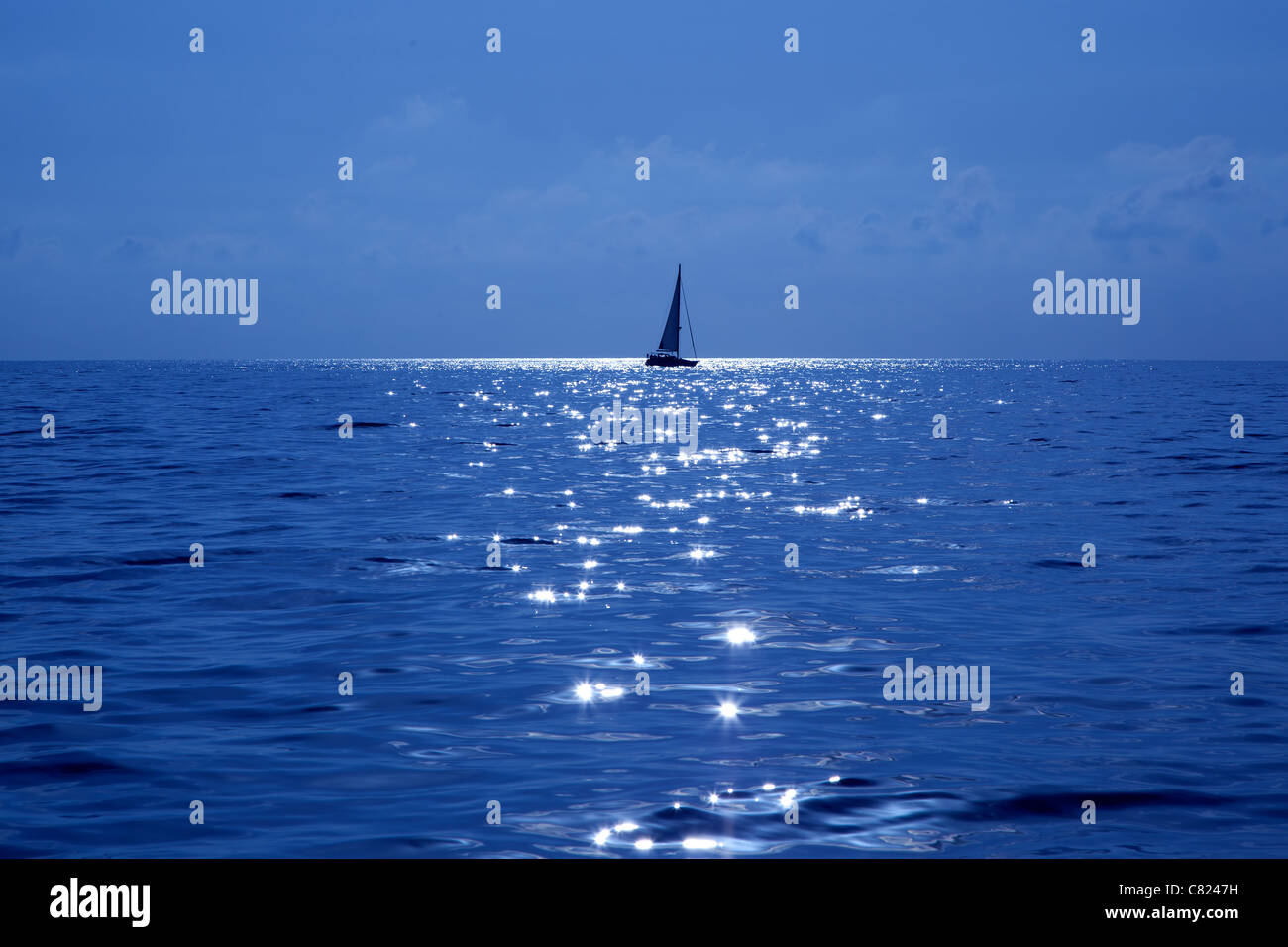blue sailboat sailing mediterranean sea with water horizon Stock Photo