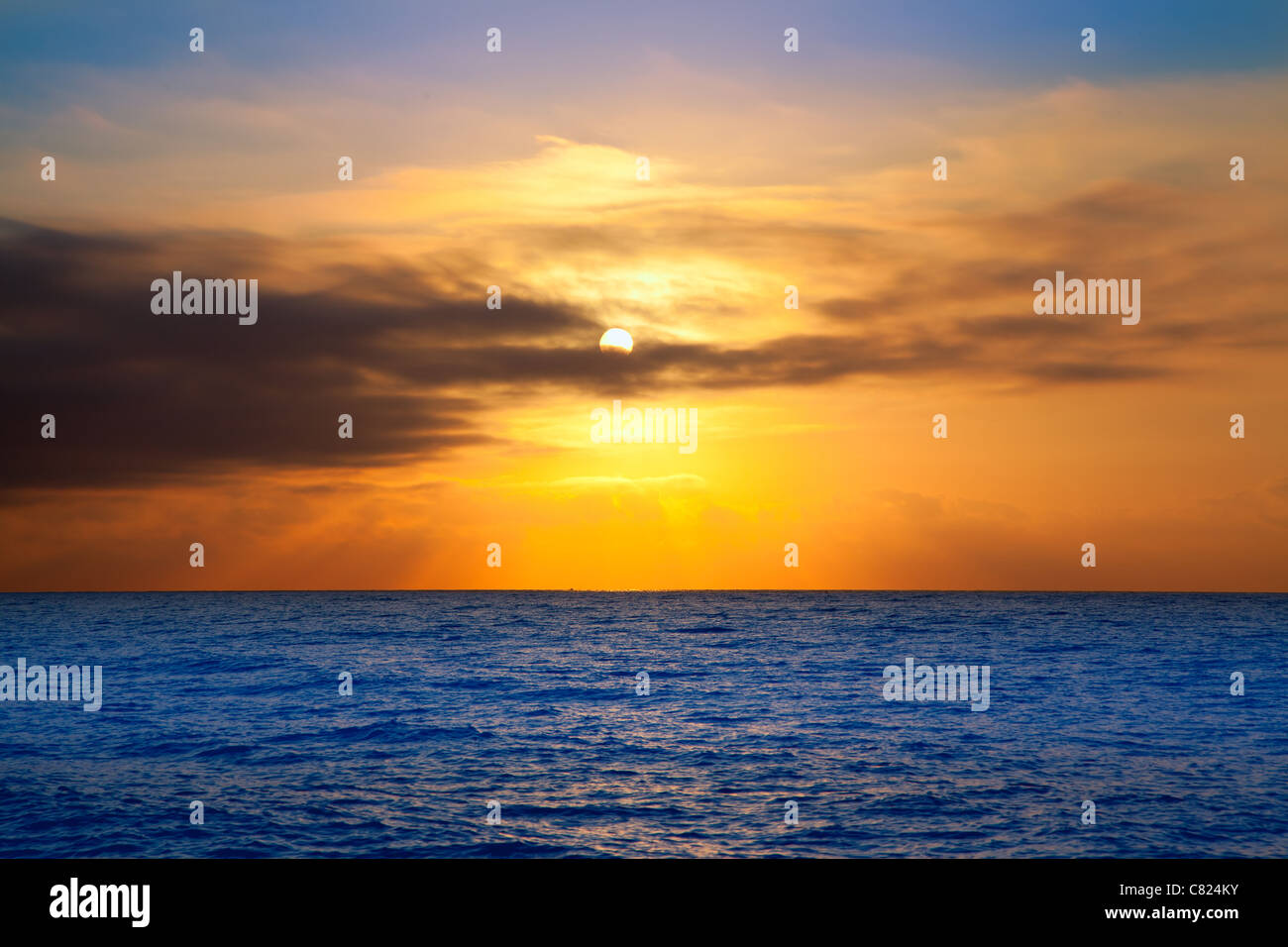 golden sunrise with sun and clouds over blue Mediterranean sea Stock Photo