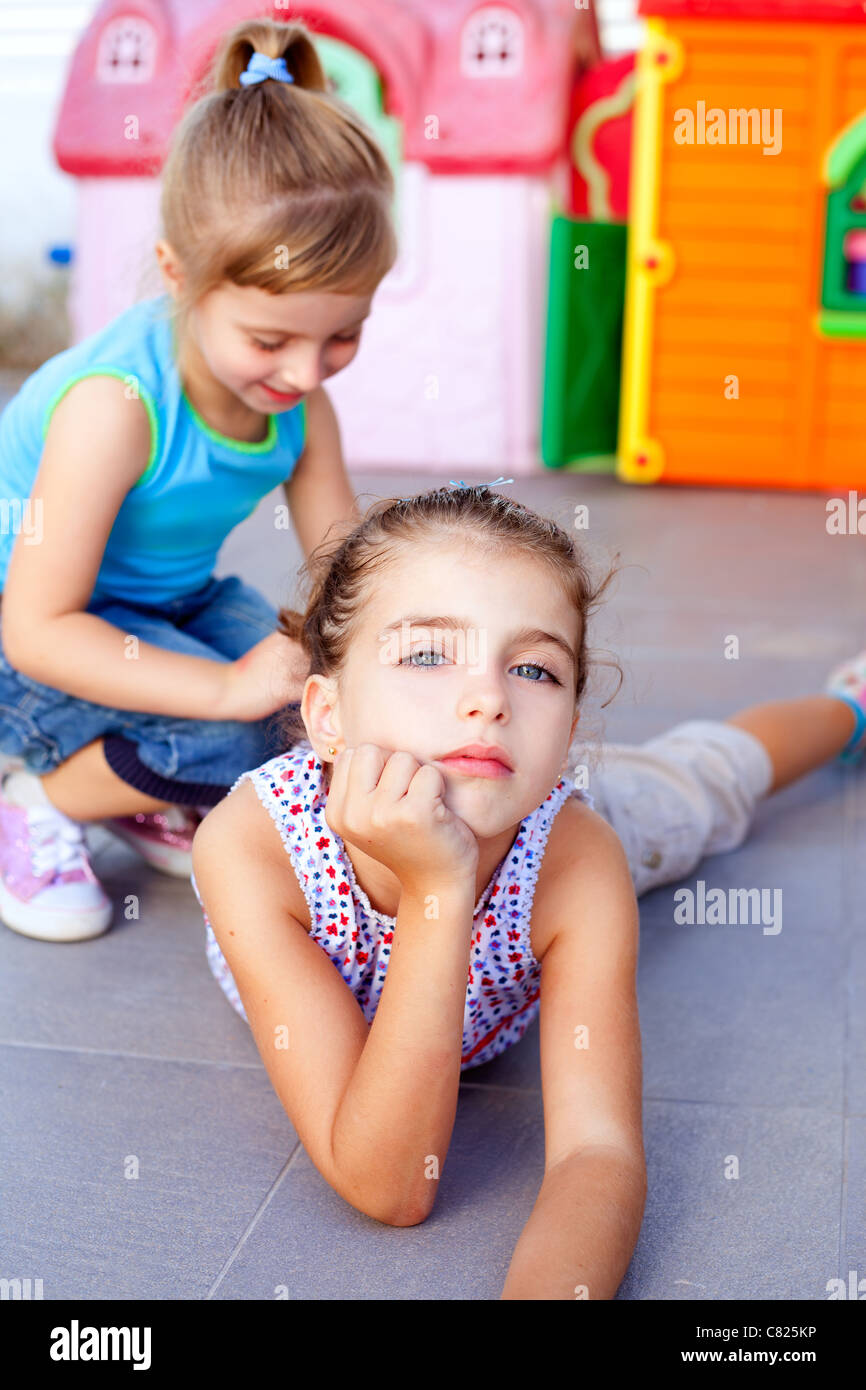 beautiful little little girls lying on floor playing in playground