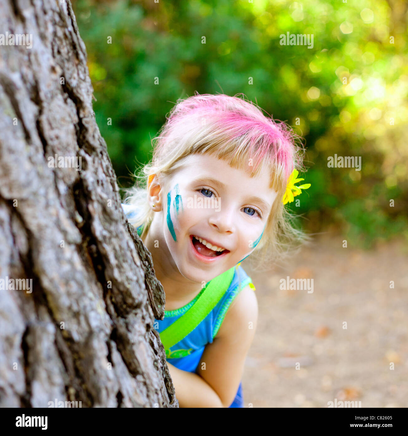 children little girl happy playing in forest tree with party makeup Stock Photo