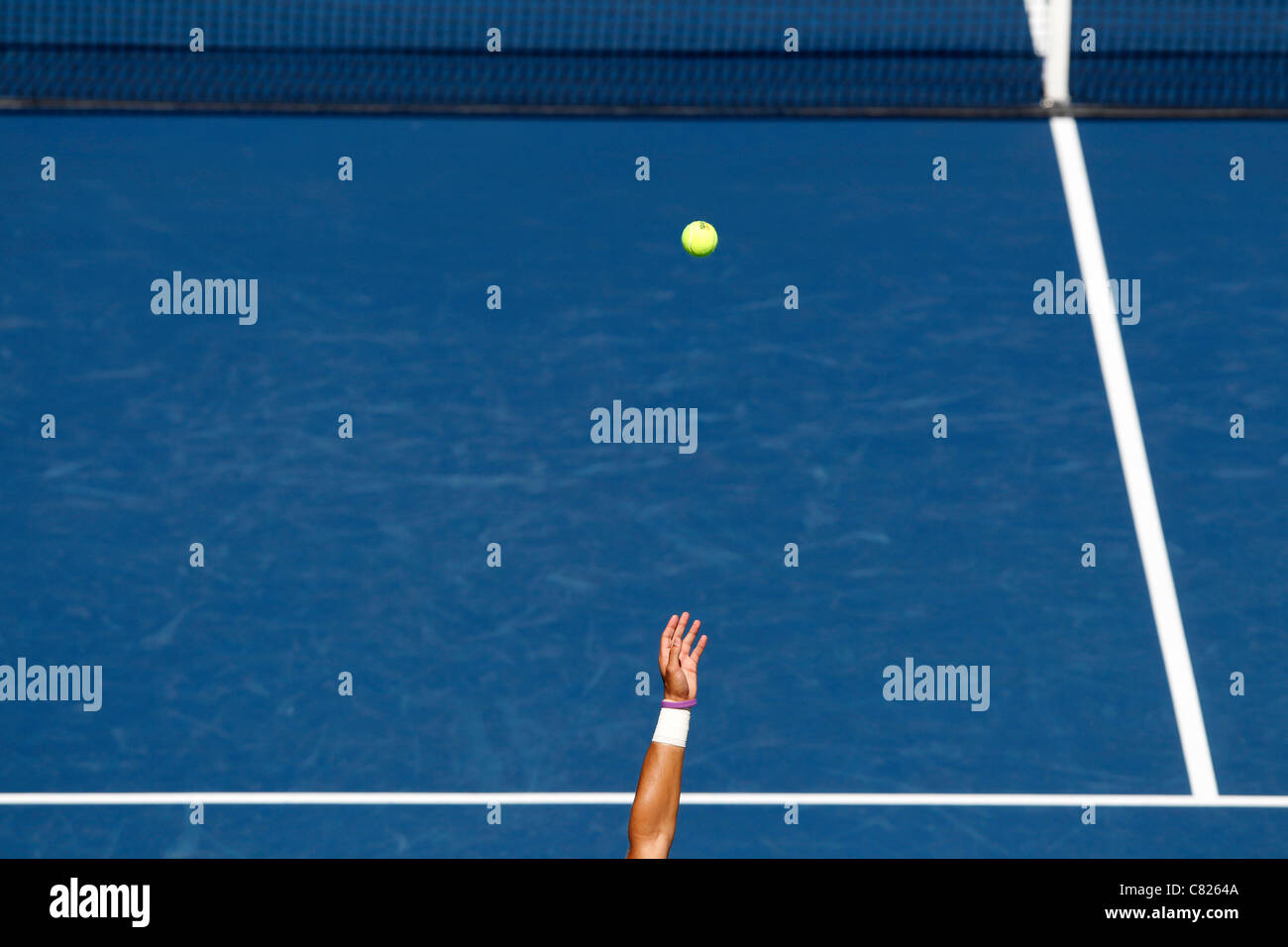 Tennis serve, arm tossing the ball in the air in front of the net at the US Open 2011 tennis tournament Stock Photo