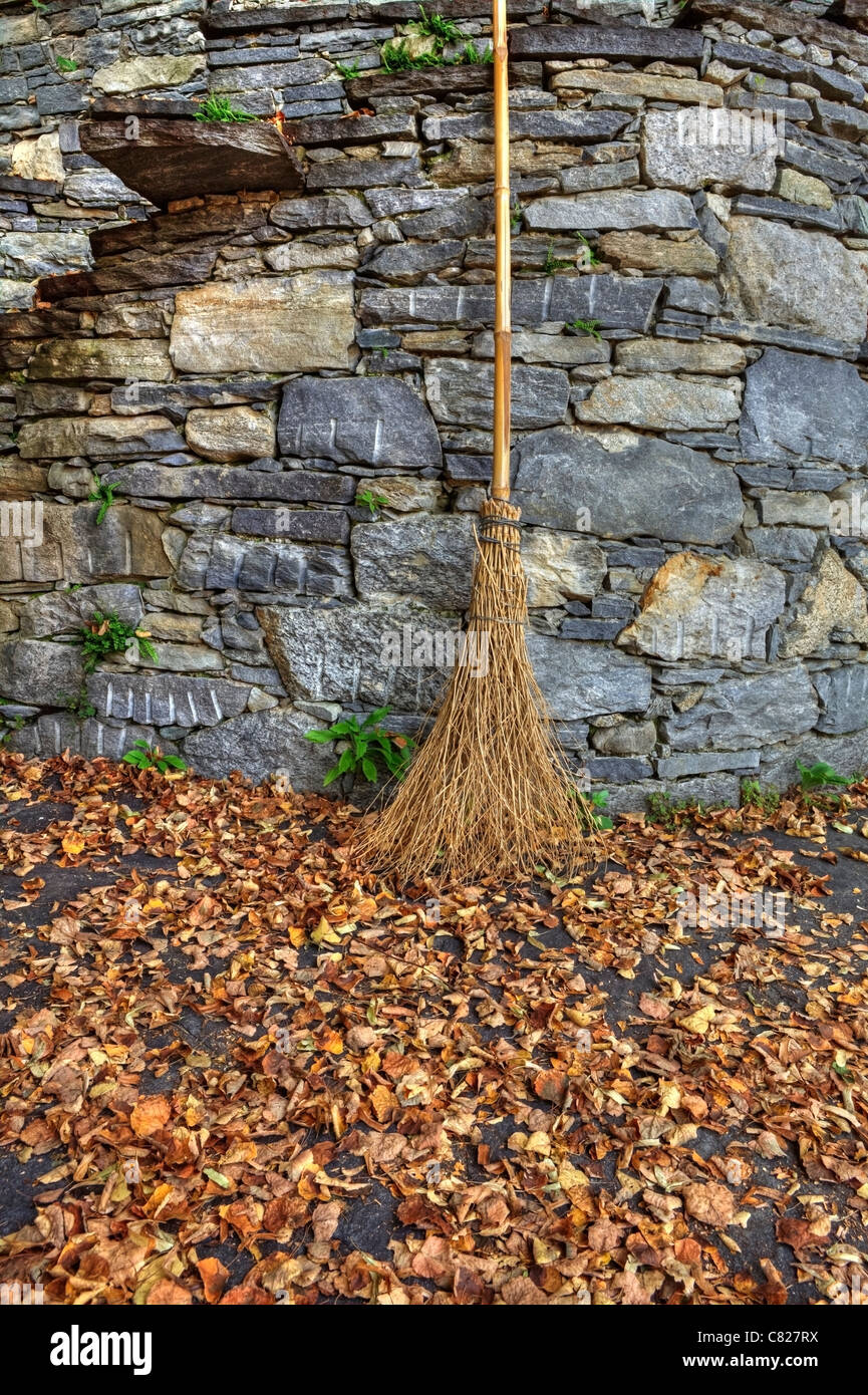 a broom with autumn leaves Stock Photo
