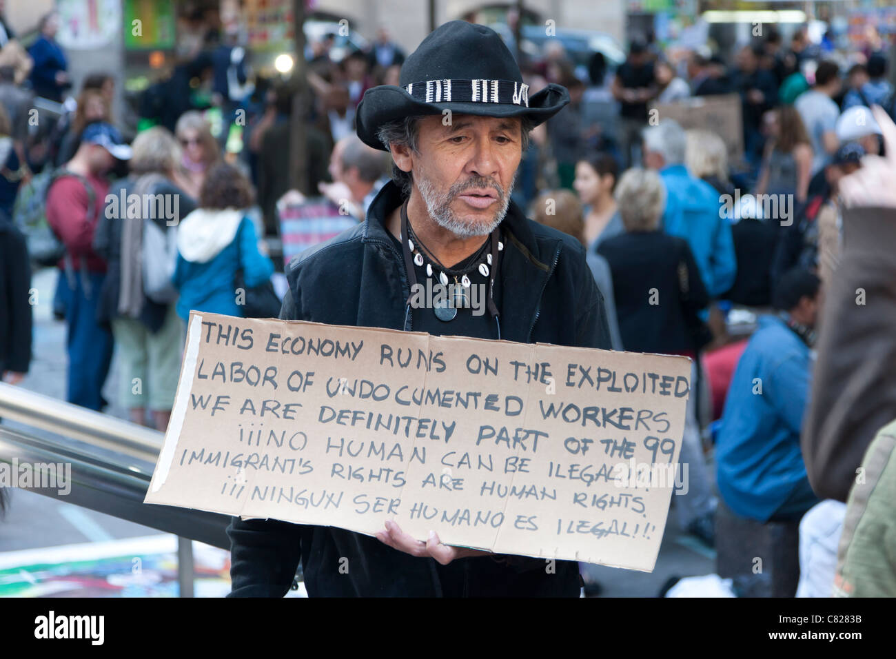 A man holds a protest sign in expressing concern for undocumented workers and immigrants during Occupy Wall Street demonstration Stock Photo