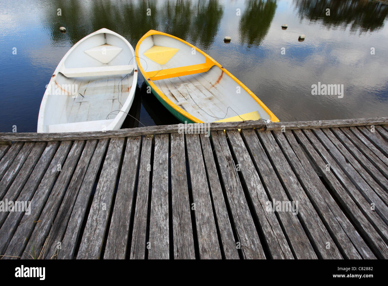 Two boats tied to wooden dock. Stock Photo