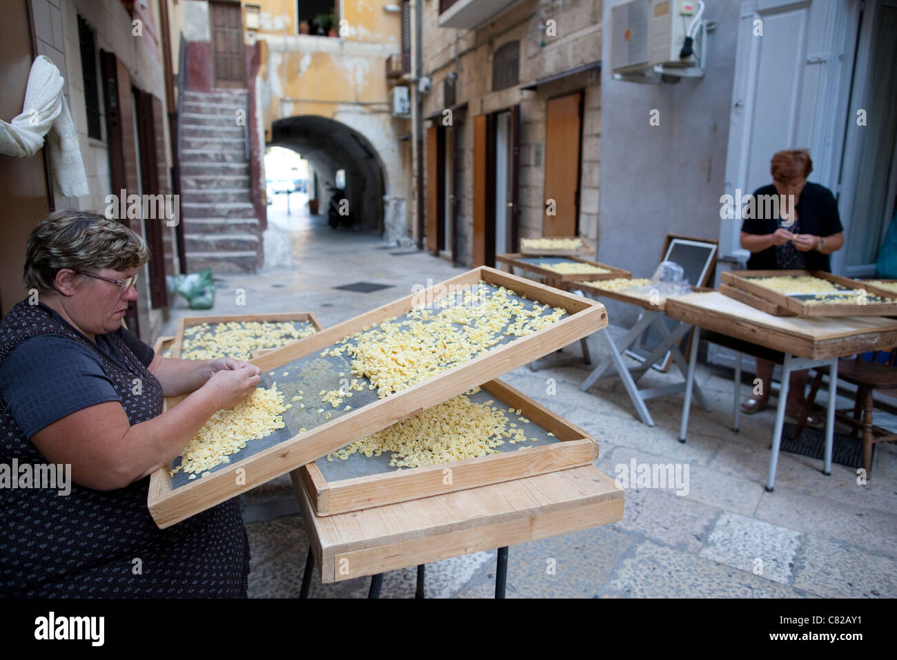 Woman making Pastaon the Medieval streets of Bari old town, Puglia Italy. Photo:Jeff Gilbert Stock Photo