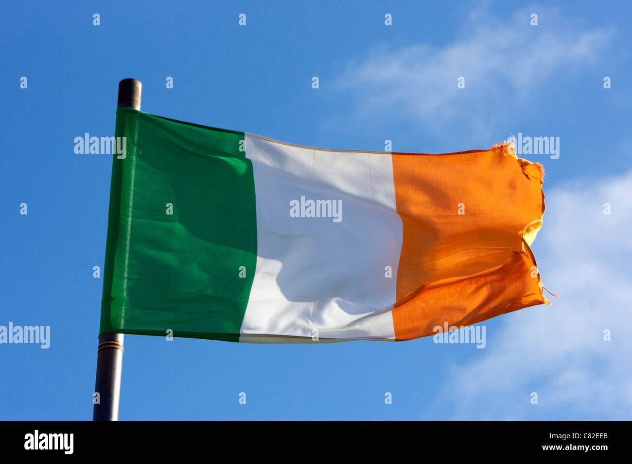 irish tricolour flag with frayed edges flying in republic of ireland Stock Photo