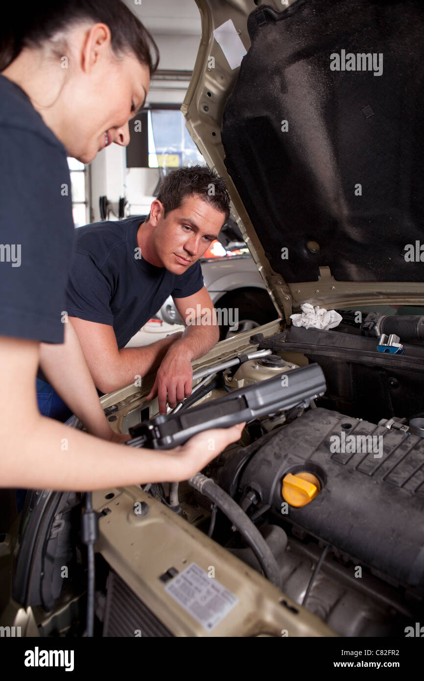 A team of mechanics using an electronic diagnostics tool Stock Photo