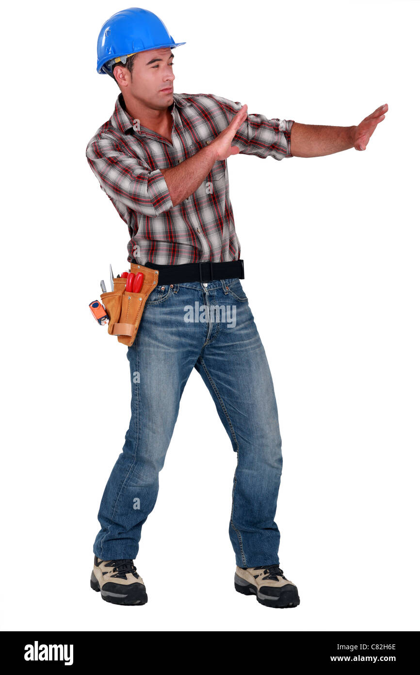 Tradesman trying to protect himself from a shooting object Stock Photo