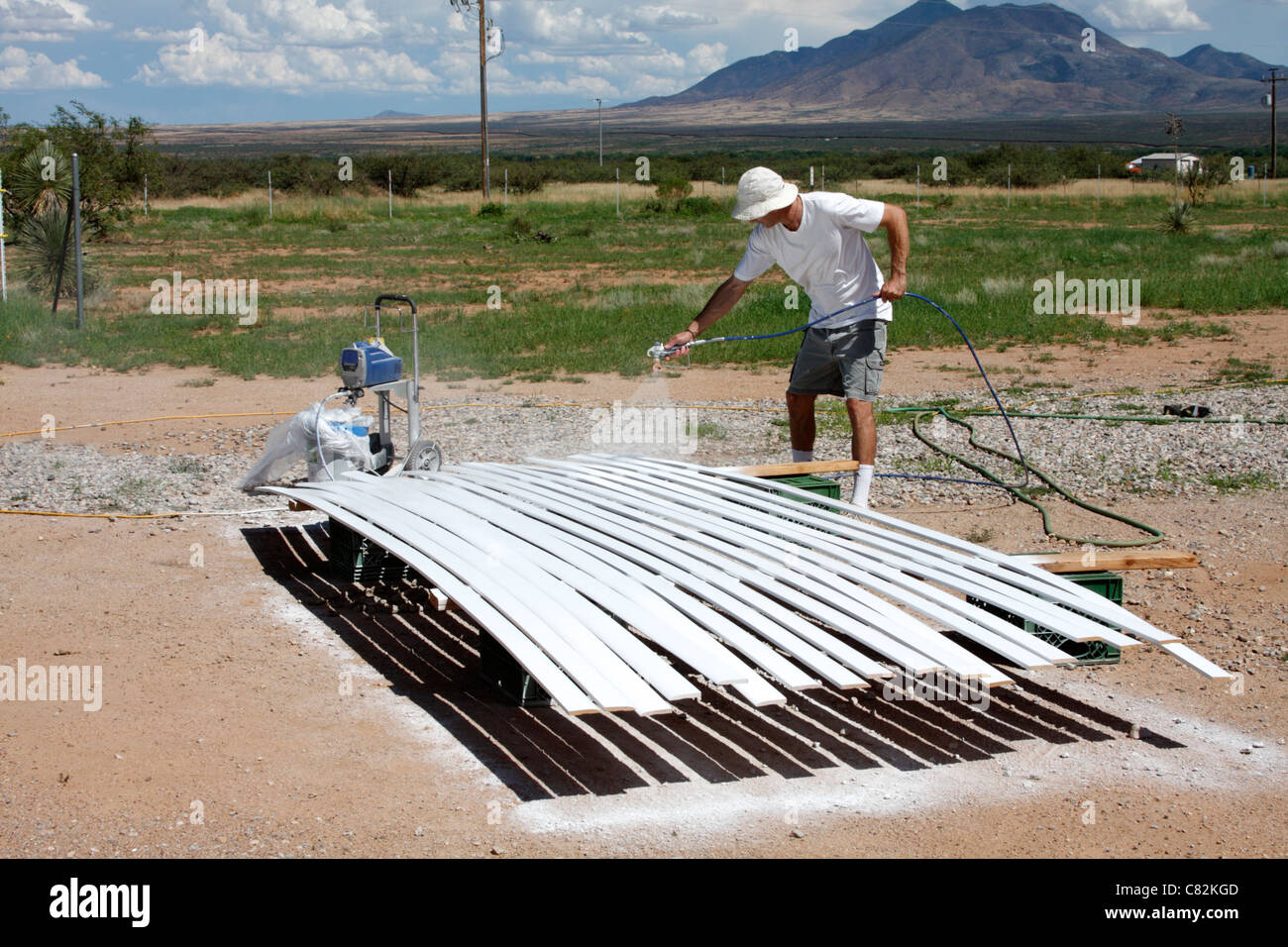 Man painting trimming with airless paint sprayer Stock Photo Alamy