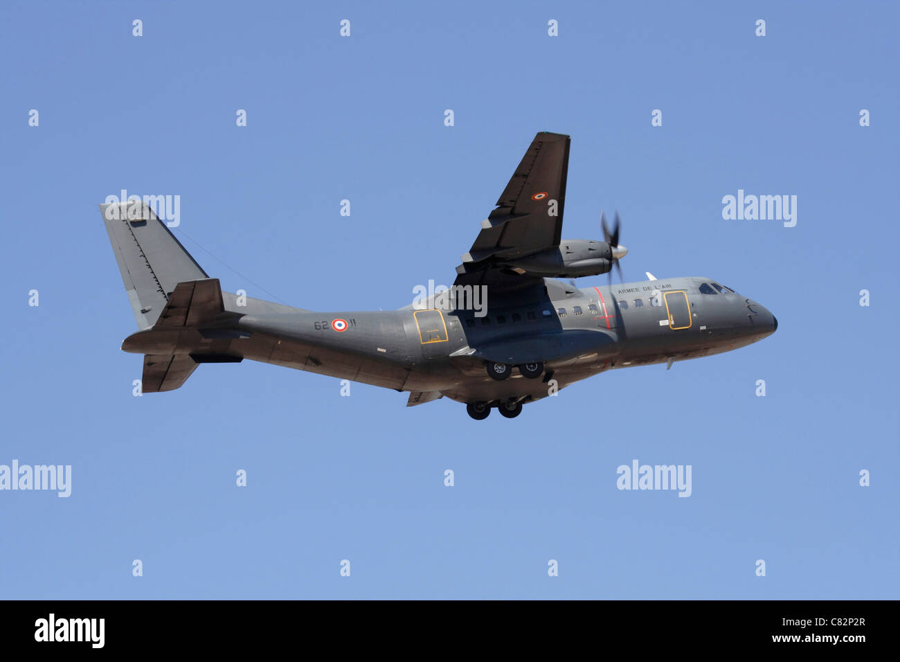 French Air Force CASA CN-235 light military transport plane on takeoff against a clear blue sky Stock Photo