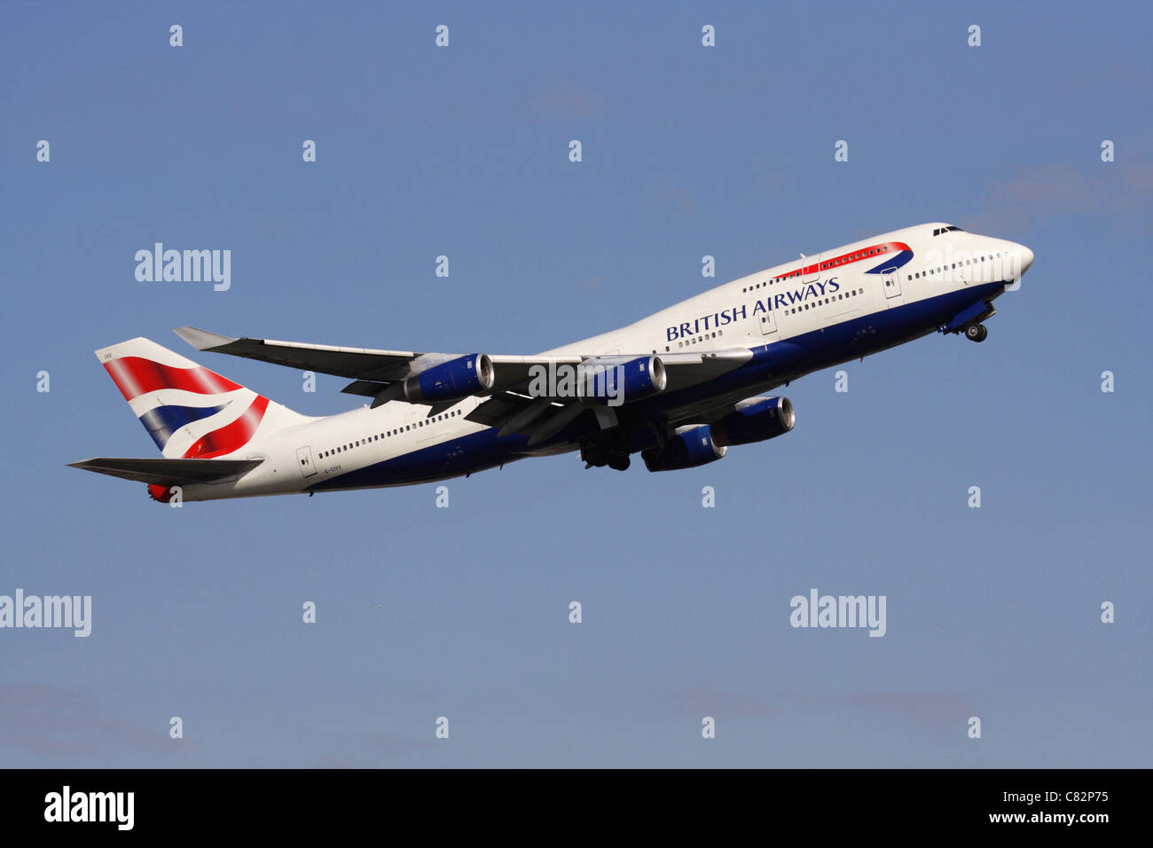 British Airways Boeing 747-400 jumbo jet plane climbing on takeoff against a clear blue sky. Side view. Stock Photo