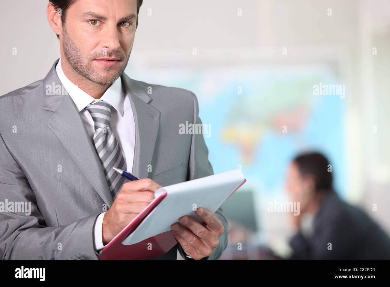 Businessman writing on a clipboard Stock Photo - Alamy