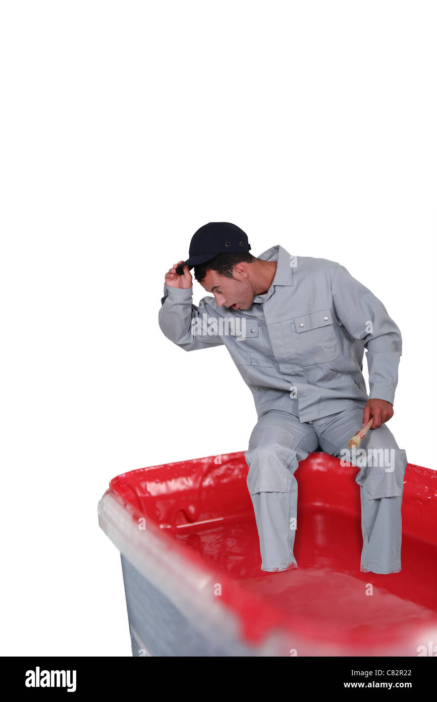 Surprised man sitting on a paint can Stock Photo